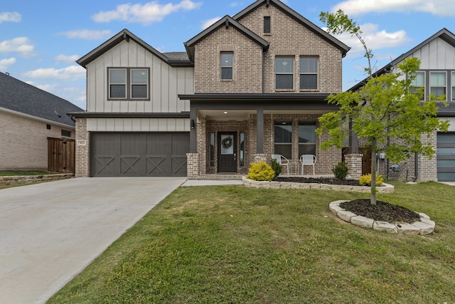view of front of property with board and batten siding, brick siding, a front yard, driveway, and an attached garage