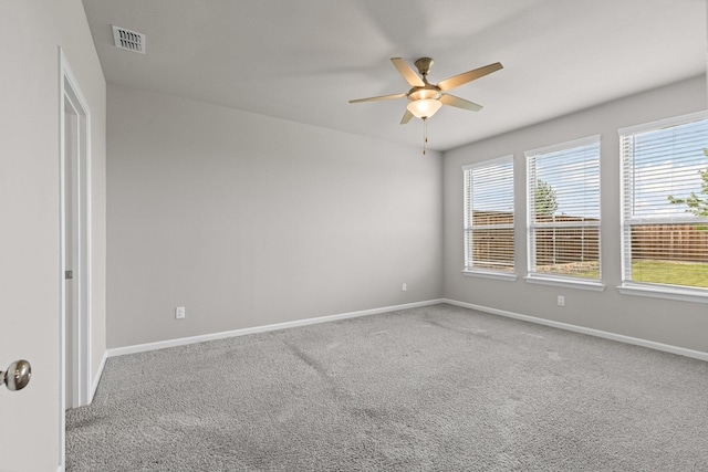 carpeted empty room with ceiling fan, baseboards, and healthy amount of natural light