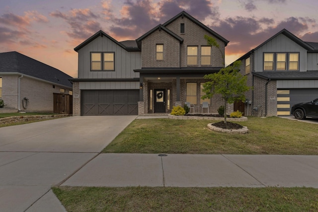 view of front of home featuring brick siding, board and batten siding, an attached garage, driveway, and a front lawn