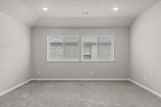 carpeted spare room featuring recessed lighting, baseboards, and vaulted ceiling
