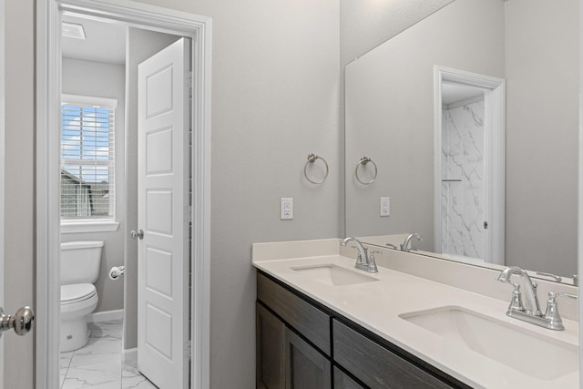 full bathroom with toilet, marble finish floors, double vanity, and baseboards