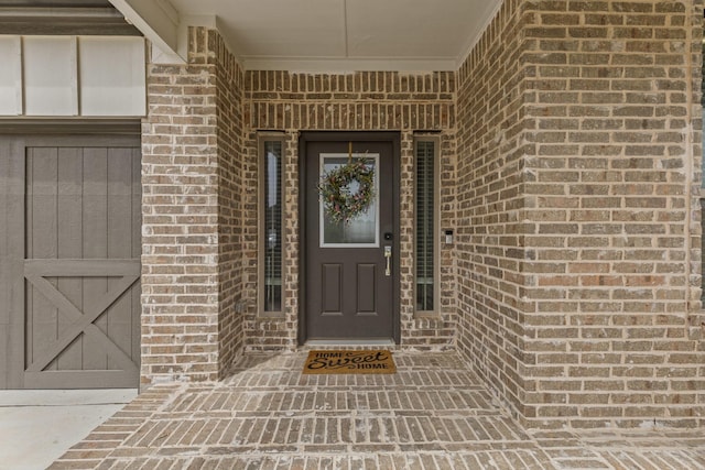 view of exterior entry with brick siding