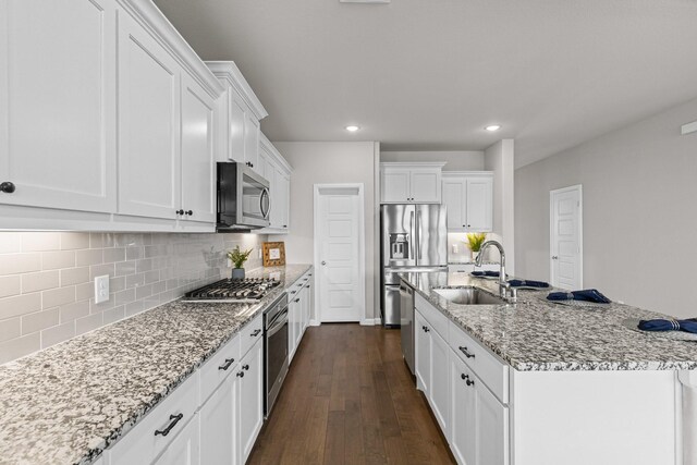 kitchen featuring appliances with stainless steel finishes, a sink, dark wood finished floors, recessed lighting, and white cabinetry