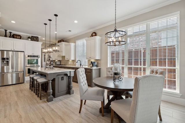 850 Long Valley Ct, Prosper, TX 75078 - dining space with a chandelier, ornamental molding, plenty of natural light, light wood-type flooring, and recessed lighting