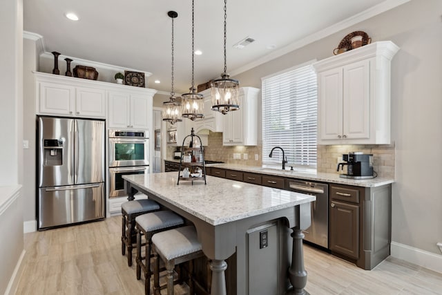 850 Long Valley Ct, Prosper, TX 75078 - kitchen with appliances with stainless steel finishes, a sink, backsplash, white cabinetry, and crown molding