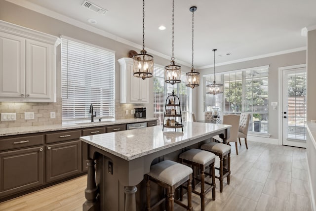 850 Long Valley Ct, Prosper, TX 75078 - kitchen with a sink, a chandelier, white cabinetry, decorative backsplash, and ornamental molding
