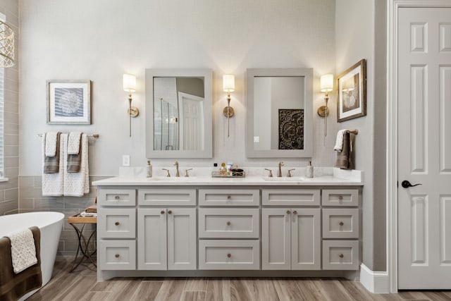 850 Long Valley Ct, Prosper, TX 75078 - bathroom with a soaking tub, double vanity, wood finished floors, and tile walls