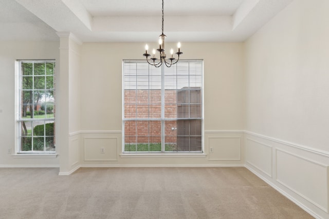 10008 Preston Vineyard Dr, Frisco, TX 75035 - unfurnished dining area with a chandelier, a raised ceiling, light colored carpet, wainscoting, and a decorative wall