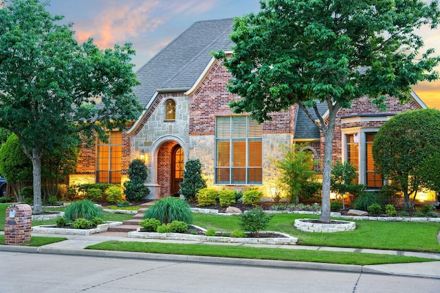 1727 Lantana Ln, Frisco, TX 75033 - tudor-style house featuring brick siding, stone siding, and a front lawn