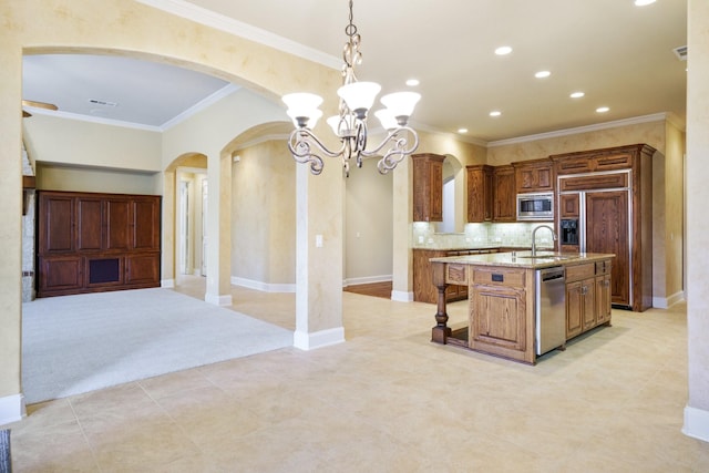 1727 Lantana Ln, Frisco, TX 75033 - kitchen with arched walkways, stainless steel appliances, a sink, open floor plan, and light stone countertops