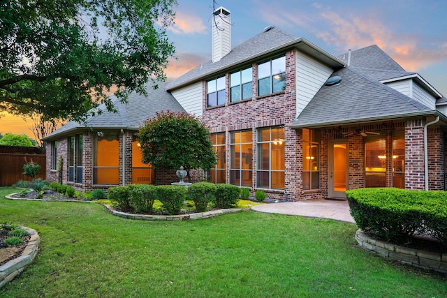 1727 Lantana Ln, Frisco, TX 75033 - back of property at dusk featuring brick siding, a chimney, roof with shingles, and a patio