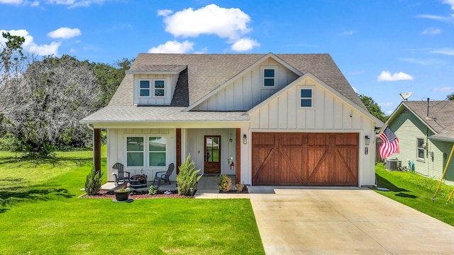 modern farmhouse featuring a porch, board and batten siding, a garage, a front lawn, and a shingled roof
