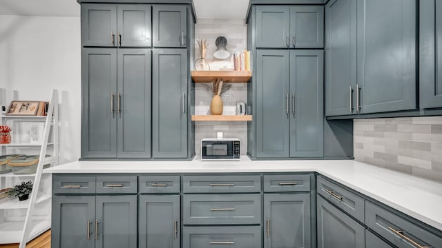 kitchen featuring open shelves, decorative backsplash, light countertops, and gray cabinetry