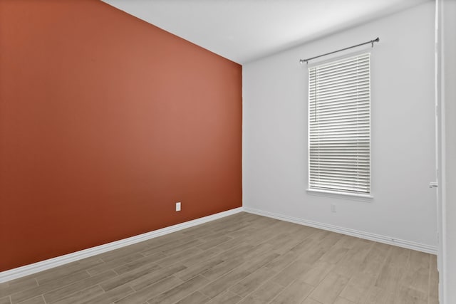 unfurnished room with light wood-style floors and baseboards