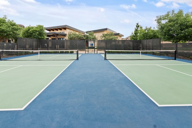 view of tennis court featuring community basketball court and fence