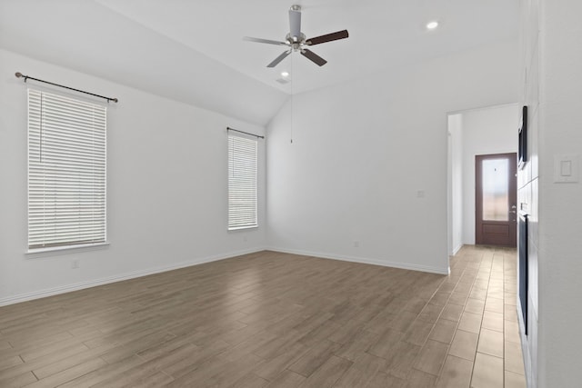 spare room featuring a ceiling fan, light wood-style floors, vaulted ceiling, baseboards, and recessed lighting