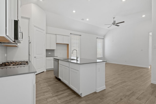 kitchen with a sink, stainless steel appliances, ceiling fan, vaulted ceiling, and tasteful backsplash