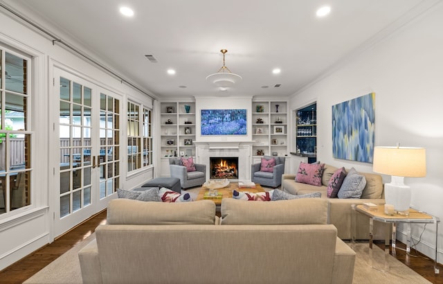 3428 Stanford Ave, University Park, TX 75225 - living room featuring crown molding, recessed lighting, a warm lit fireplace, wood finished floors, and built in features