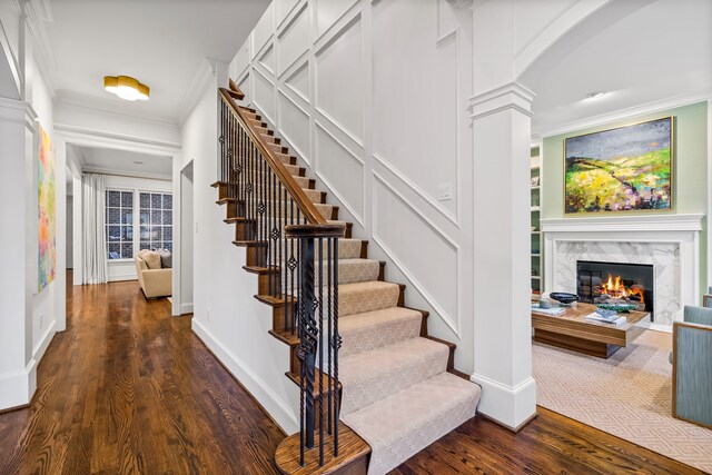 3428 Stanford Ave, University Park, TX 75225 - stairs featuring wood finished floors, crown molding, a fireplace, baseboards, and arched walkways
