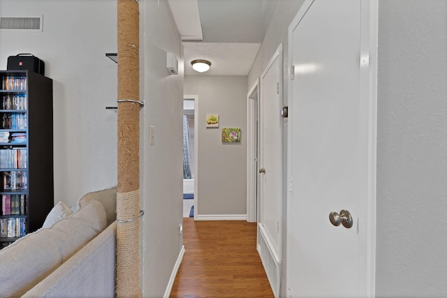 corridor with wood finished floors and baseboards