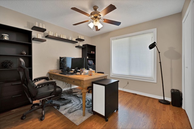 office with ceiling fan, wood finished floors, a textured ceiling, and baseboards