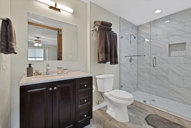 full bath with toilet, a stall shower, ceiling fan, and vanity