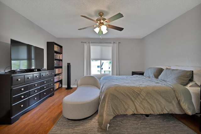 bedroom featuring wood finished floors, a textured ceiling, and ceiling fan