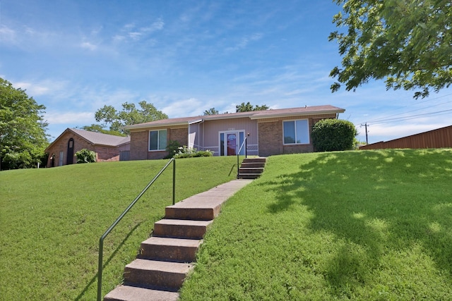 single story home featuring brick siding and a front yard