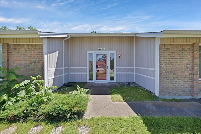 view of exterior entry with brick siding