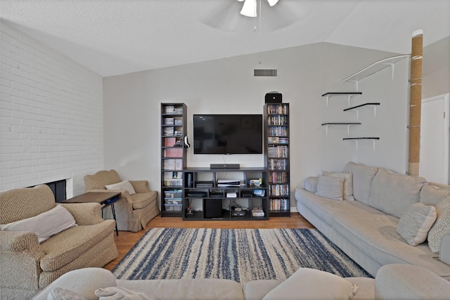 living room featuring a ceiling fan, wood finished floors, and brick wall