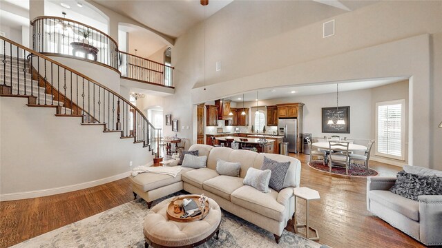 2705 Brunswick Cv, Trophy Club, TX 76262 - living room with wood finished floors, stairs, arched walkways, baseboards, and a towering ceiling