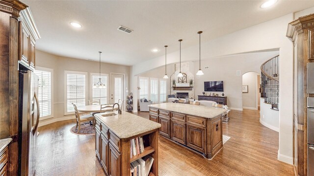 2705 Brunswick Cv, Trophy Club, TX 76262 - kitchen with a kitchen island with sink, a sink, open floor plan, stainless steel fridge, and baseboards