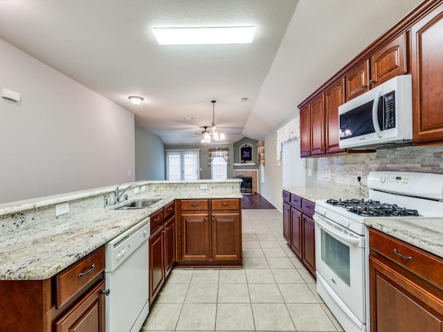 kitchen with white appliances, a sink, a fireplace, a ceiling fan, and backsplash