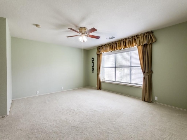 empty room featuring a ceiling fan, carpet flooring, and baseboards