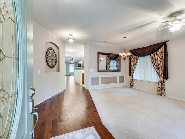 foyer featuring a ceiling fan, a chandelier, hardwood / wood-style flooring, and baseboards