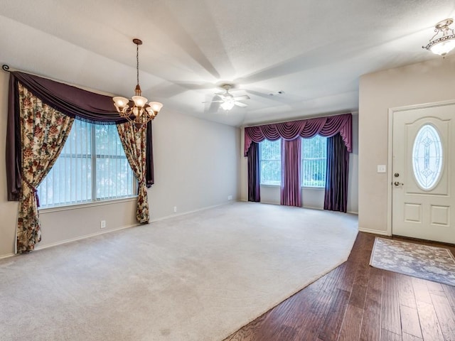 entryway featuring a chandelier, baseboards, wood finished floors, and a ceiling fan