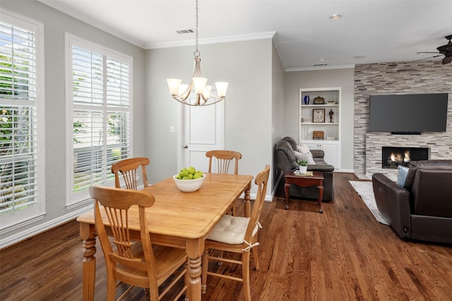 dining room featuring crown molding, dark wood-style flooring, ceiling fan, built in shelves, and a chandelier