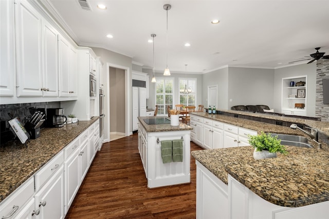 kitchen with a sink, a large island, dark wood-style flooring, a ceiling fan, and ornamental molding
