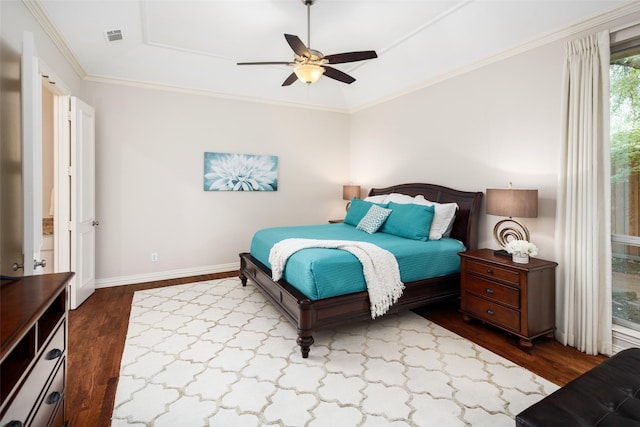 bedroom with dark wood-style flooring, a ceiling fan, baseboards, ornamental molding, and a raised ceiling