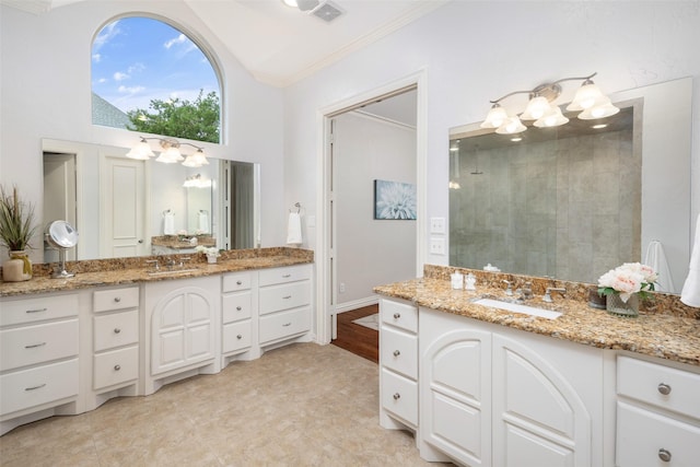 bathroom with a chandelier, crown molding, a tile shower, vanity, and high vaulted ceiling