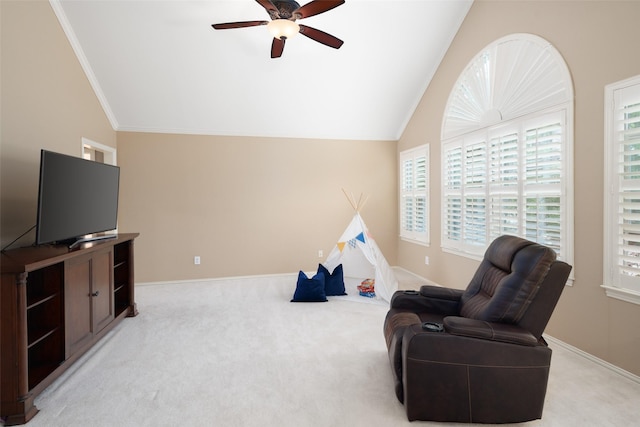 living area with lofted ceiling, ceiling fan, light colored carpet, plenty of natural light, and ornamental molding