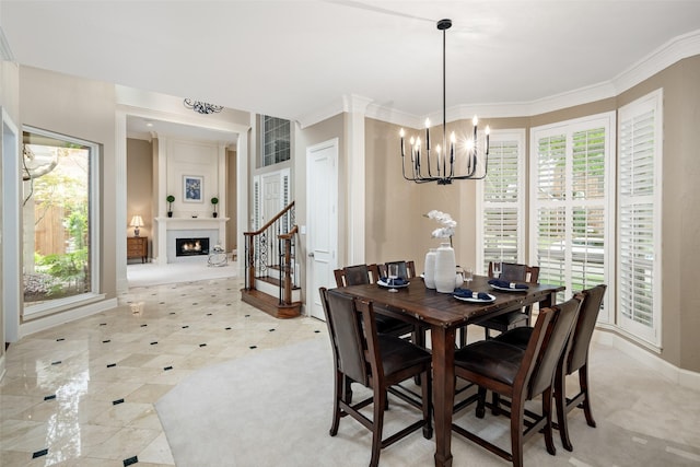 dining area featuring a chandelier, a fireplace, baseboards, and crown molding