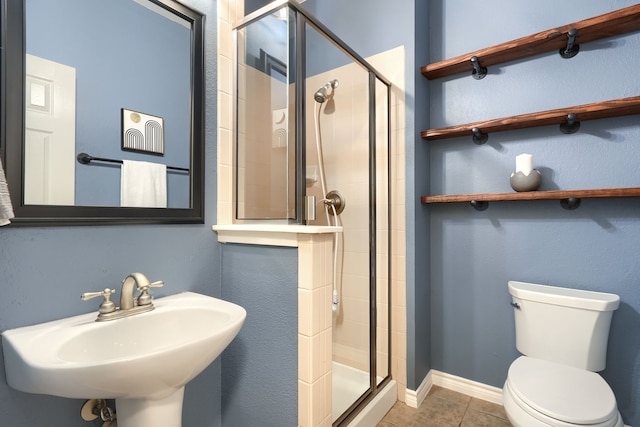 full bath featuring a shower stall, a sink, toilet, and tile patterned floors