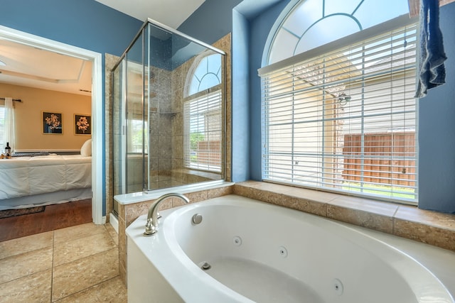 bathroom with connected bathroom, a shower stall, and a tub with jets