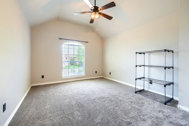 carpeted spare room featuring a ceiling fan, lofted ceiling, and baseboards