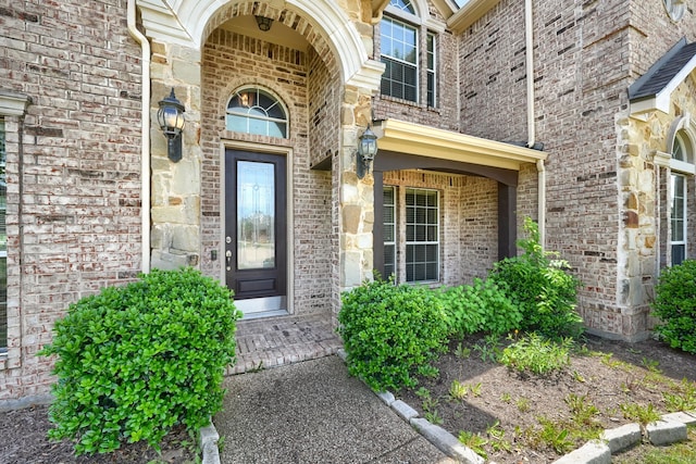 doorway to property featuring brick siding and stone siding