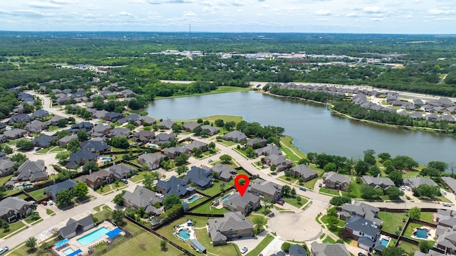 aerial view of property and surrounding area with a large body of water and nearby suburban area
