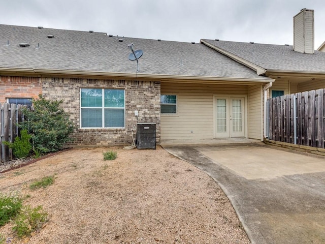 323 Emma Call Ct, Decatur, TX 76234 - rear view of property featuring french doors, fence, brick siding, and a shingled roof