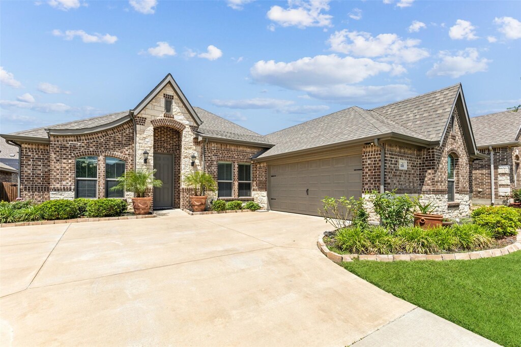 121 Quail Run Rd, Red Oak, TX 75154 - french country style house with brick siding, concrete driveway, roof with shingles, an attached garage, and stone siding