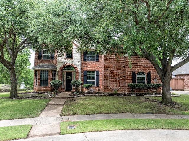 view of front of property featuring brick siding and a front lawn